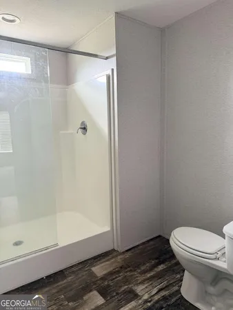 a bathroom with a toilet and a shower