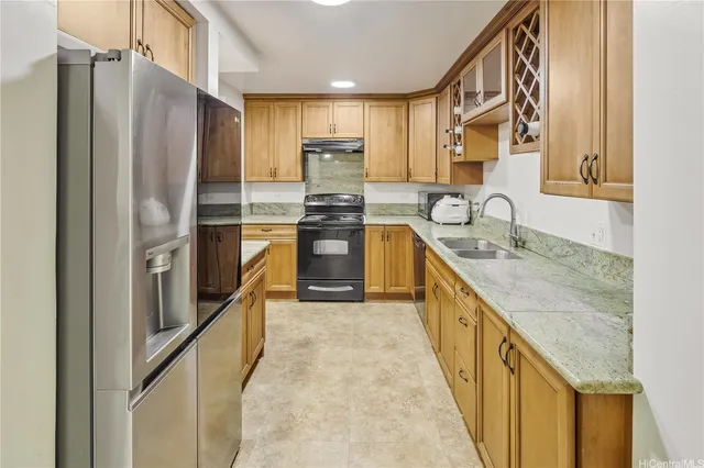 a kitchen with stainless steel appliances granite countertop a refrigerator a sink and a stove