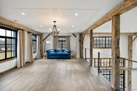 a view of livingroom with furniture staircase and windows