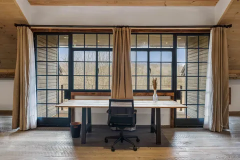 a view of a workspace with furniture and a window