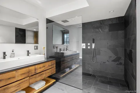 a bathroom with a double vanity sink a mirror and a shower