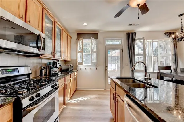 a kitchen with stainless steel appliances granite countertop a stove and a sink