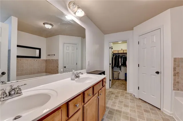 a bathroom with a sink double vanity granite and a bathtub