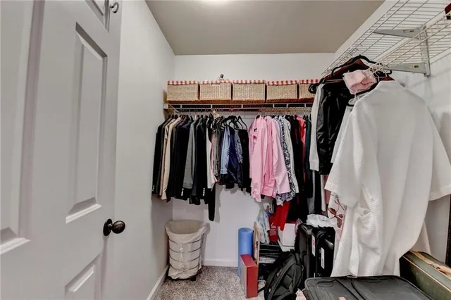 a view of walk in closet with clothes and shoes