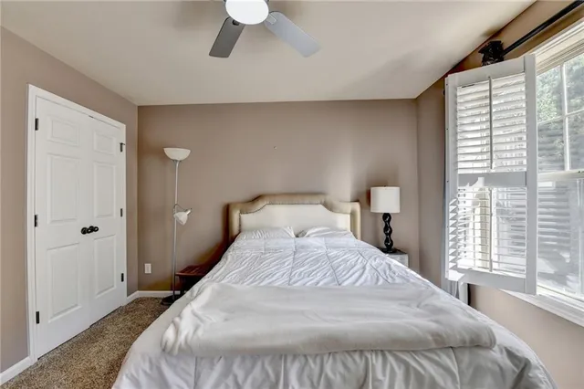 a bedroom with a bed and a large window