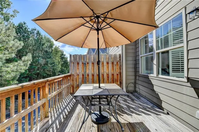 a view of a patio with a table and chairs under an umbrella