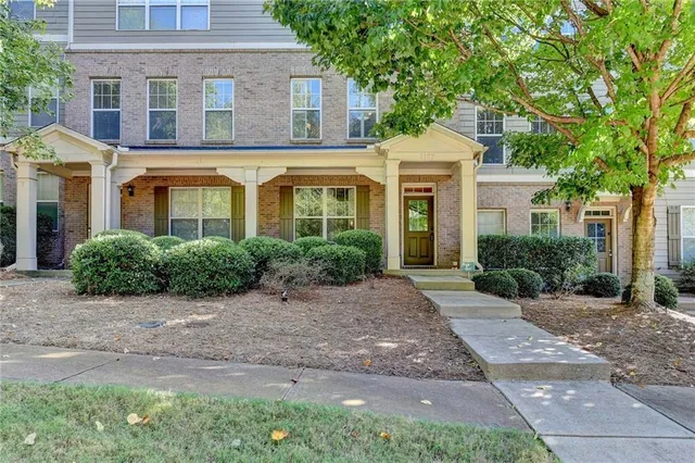 a front view of a house with yard and trees