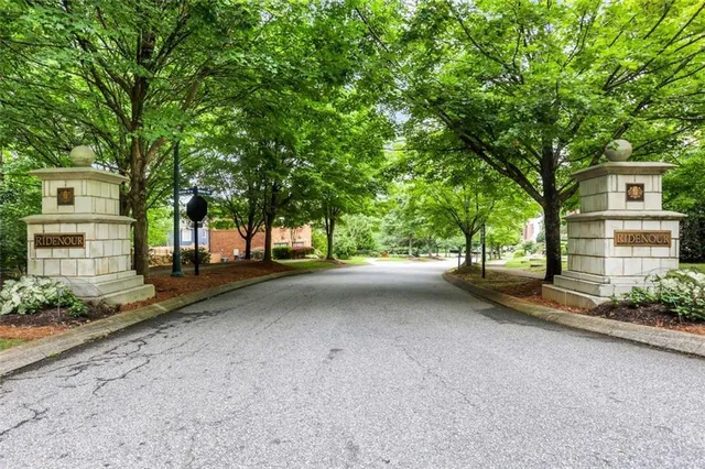 a view of a street with a house and large trees