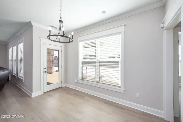 a view of a livingroom with a chandelier fan and windows