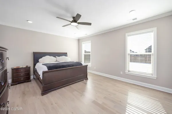 a bedroom with a large bed and a chandelier