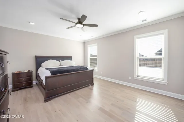 a bedroom with a large bed and a chandelier