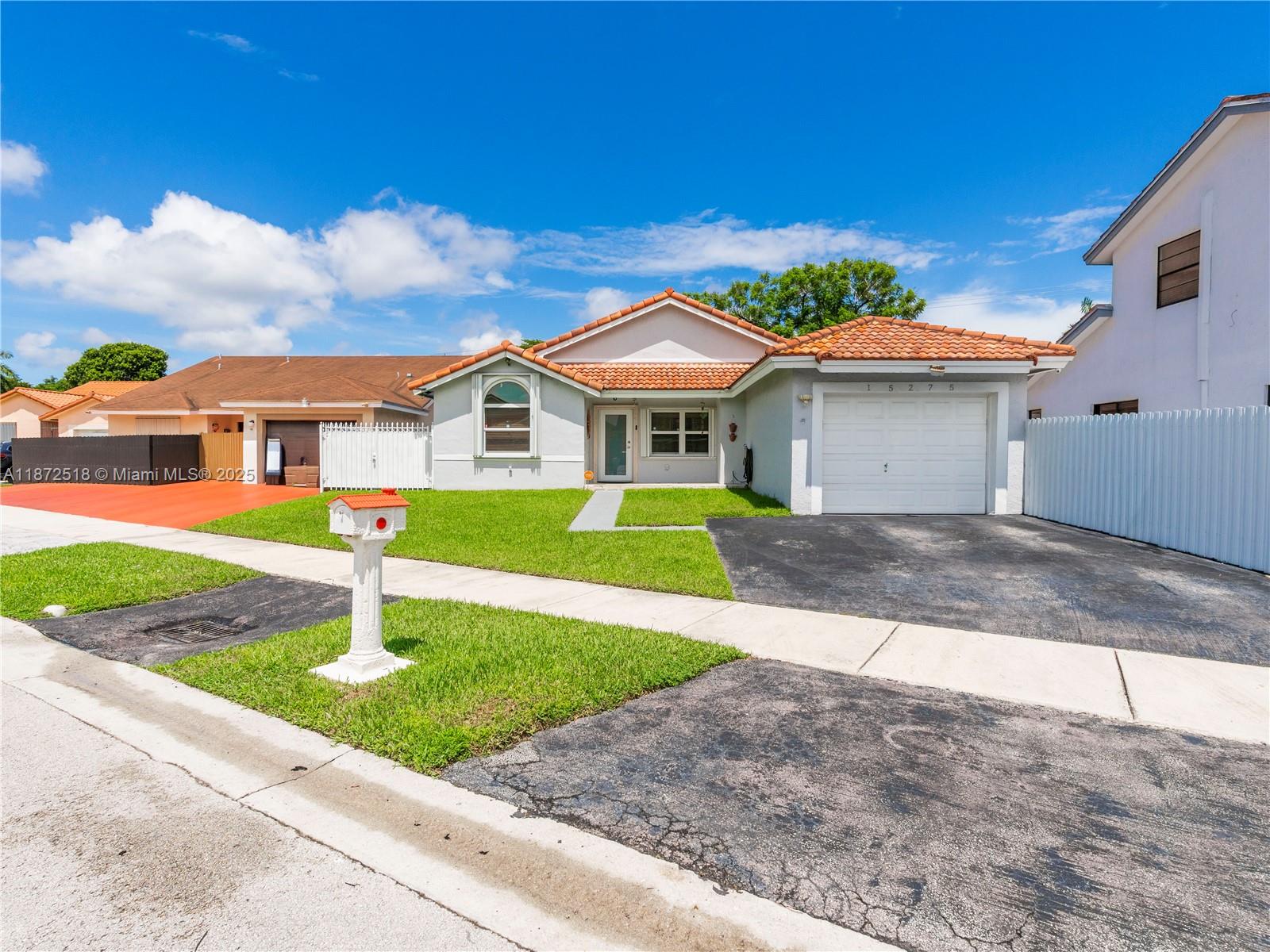 15275 Southwest 56th Terrace Miami, FL 33193 - Photo 1 of 32 a front view of a house with a yard and garage