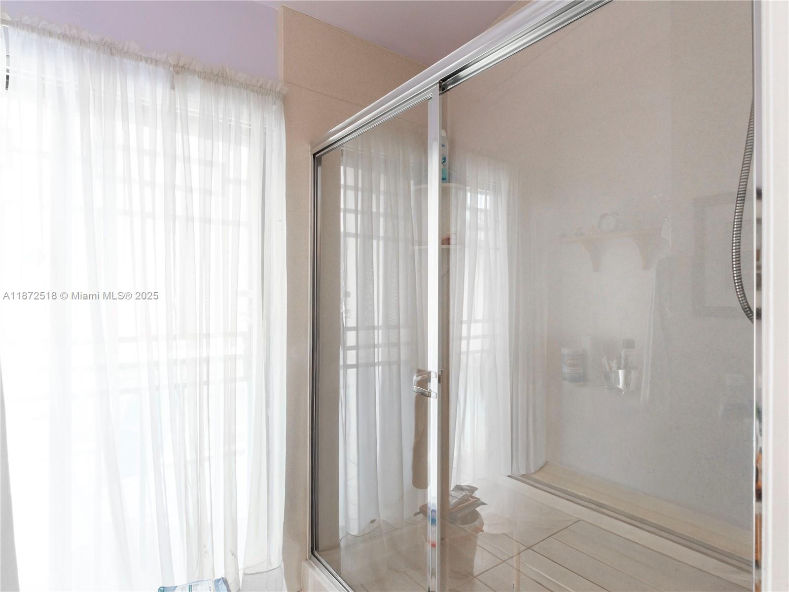 15275 Southwest 56th Terrace Miami, FL 33193 - Photo 17 of 32 a bathroom with a glass shower door