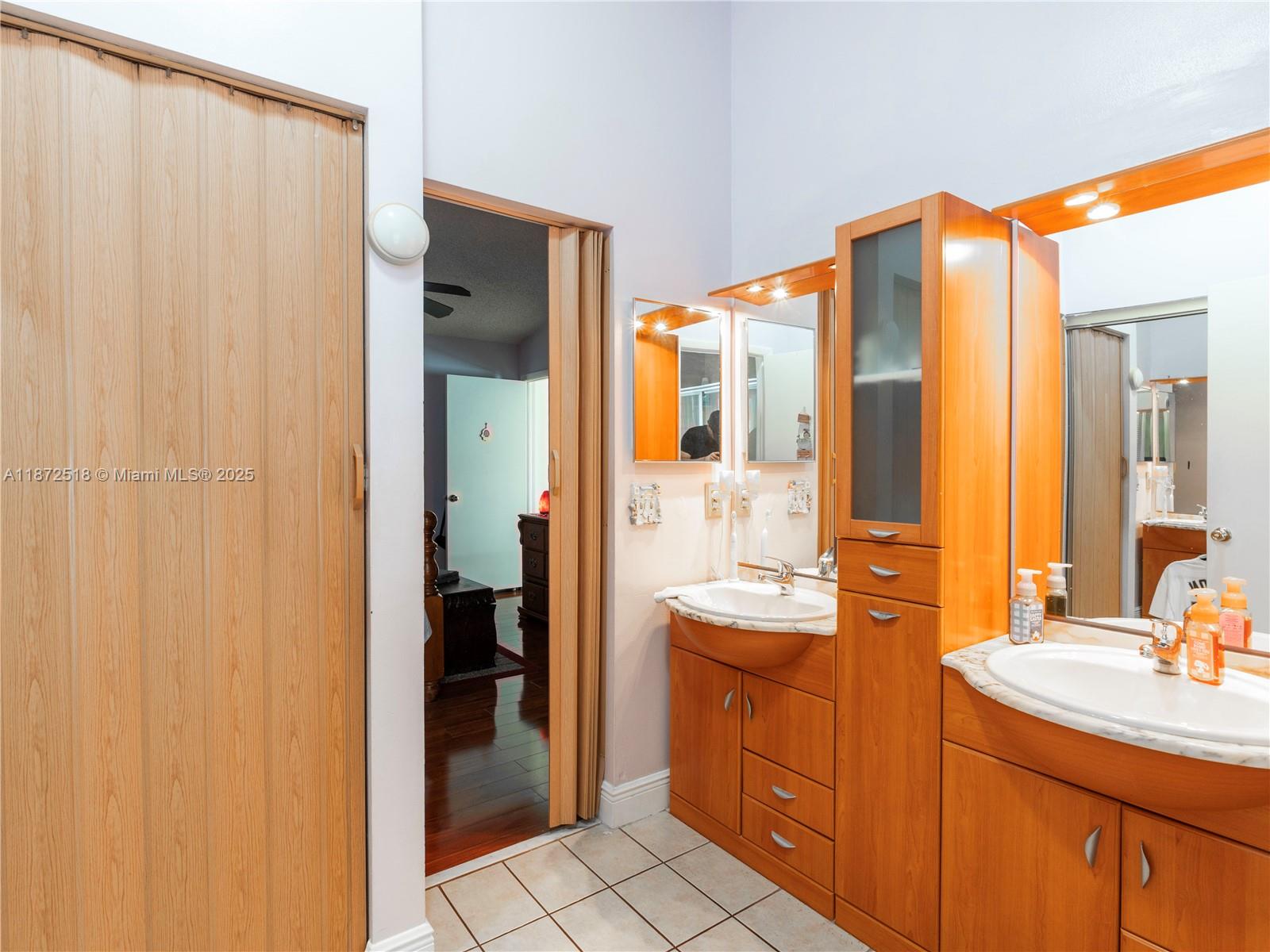 15275 Southwest 56th Terrace Miami, FL 33193 - Photo 18 of 32 a bathroom with a double vanity sink and a mirror