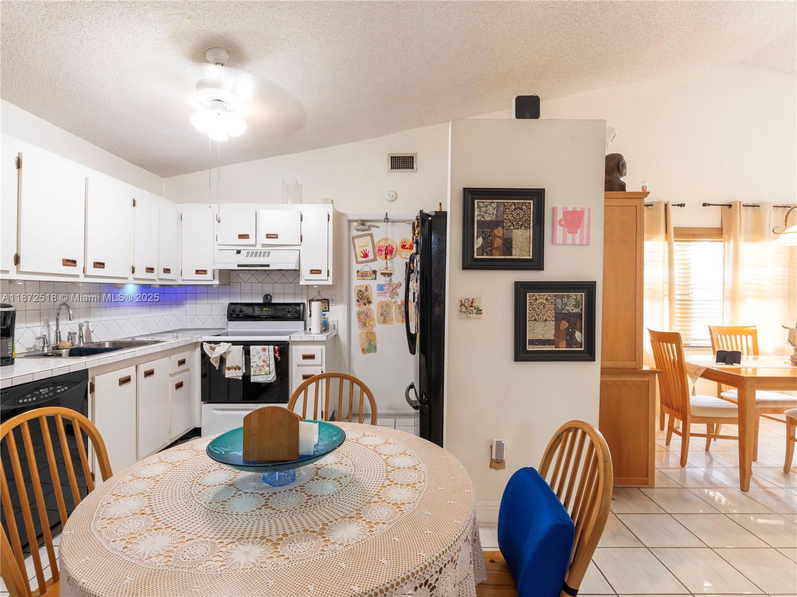 15275 Southwest 56th Terrace Miami, FL 33193 - Photo 8 of 32 a kitchen with stainless steel appliances granite countertop a stove a sink a dining table and chairs