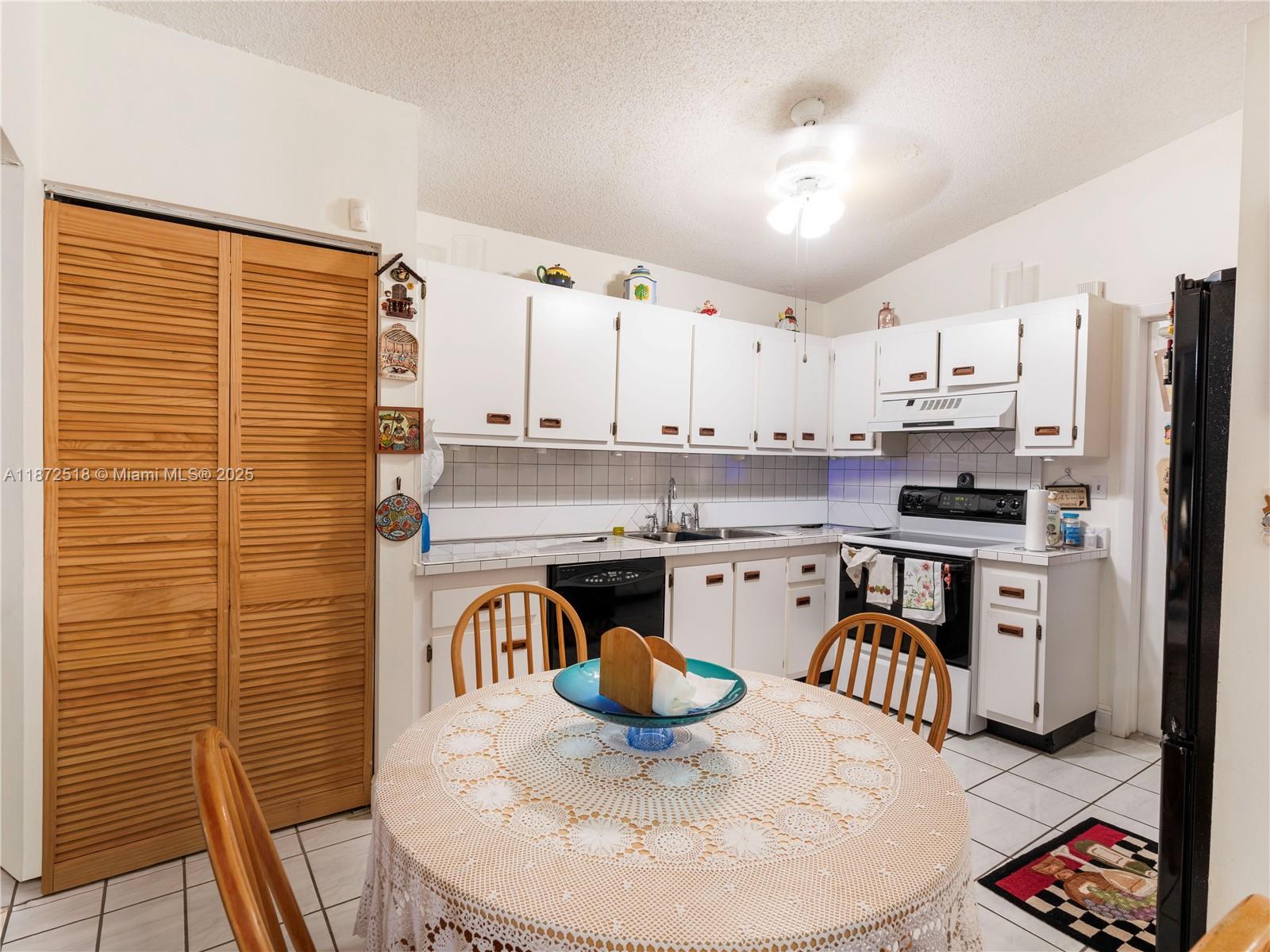 15275 Southwest 56th Terrace Miami, FL 33193 - Photo 9 of 32 a kitchen with stainless steel appliances granite countertop a stove a refrigerator a sink a dining table and chairs