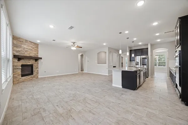 a large white kitchen with a large kitchen island sink stainless steel appliances and a couch