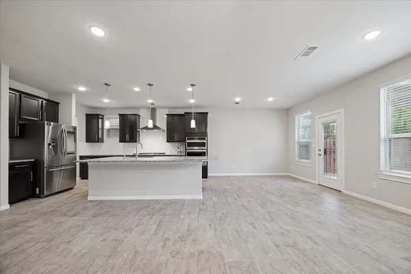 a large kitchen with stainless steel appliances kitchen island a large counter top and a sink