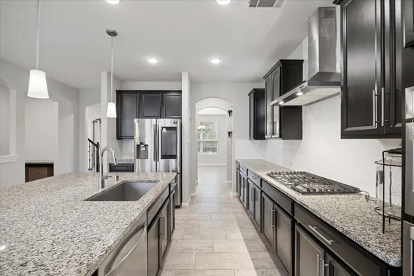 a kitchen with stainless steel appliances granite countertop a sink stove and refrigerator