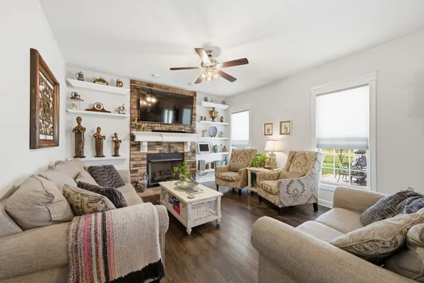 a living room with furniture a flat screen tv and a fireplace