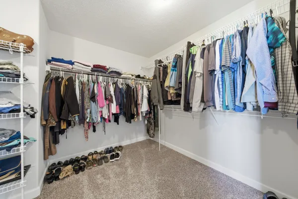 a view of walk in closet with clothes