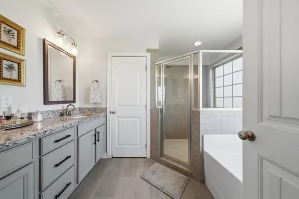 a bathroom with a granite countertop sink a mirror and a shower