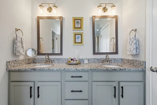 a bathroom with a granite countertop sink vanity and mirror