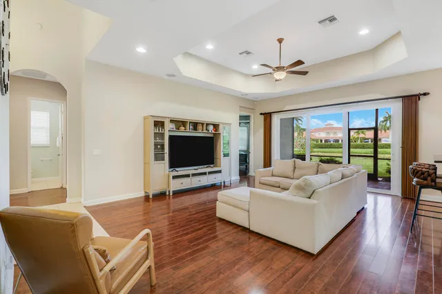 a living room with furniture a flat screen tv and a large window