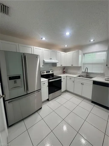 a kitchen with stainless steel appliances granite countertop a refrigerator sink and cabinets