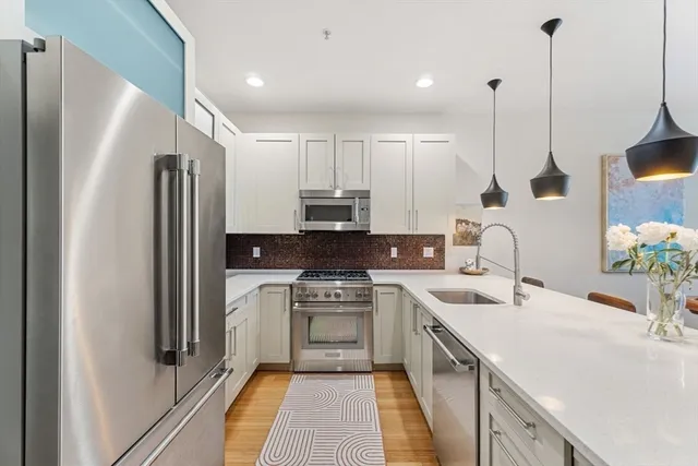 a kitchen with white cabinets and stainless steel appliances