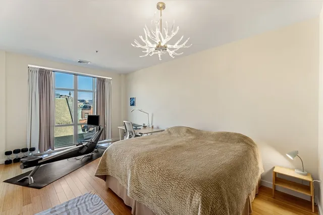 a bedroom with a bed and a chandelier