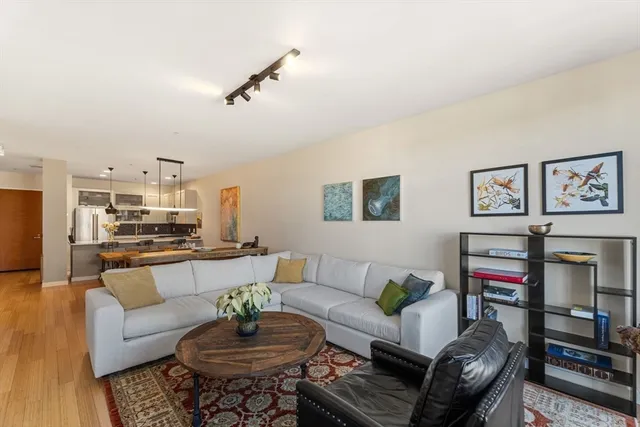 a living room with furniture a rug and a wall painting