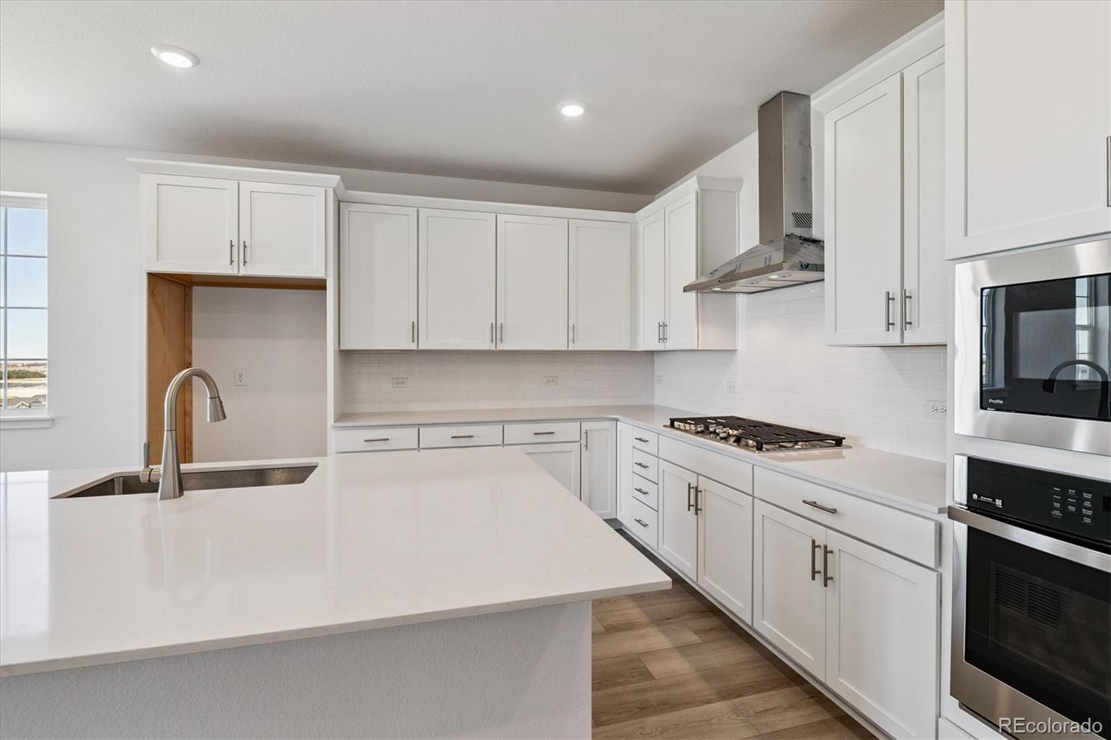 741 Lawson Drive Elizabeth, CO 80107 - Photo 11 of 27 a kitchen with stainless steel appliances granite countertop a sink stove and white cabinets