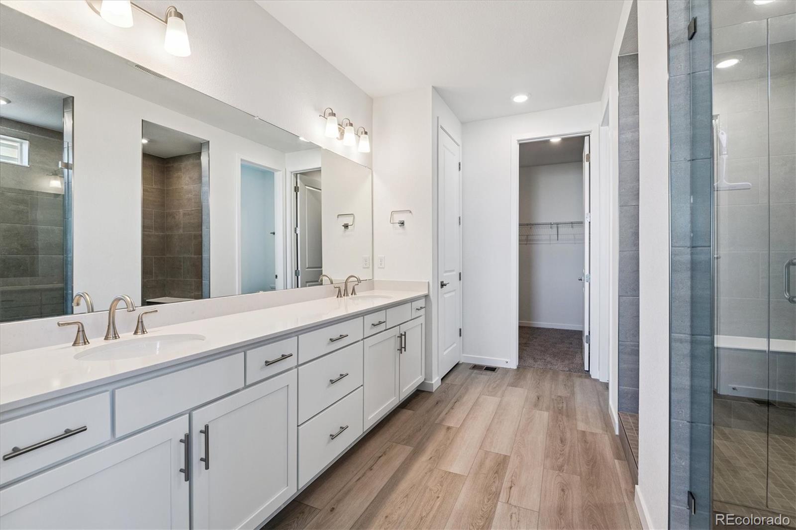 741 Lawson Drive Elizabeth, CO 80107 - Photo 20 of 27 a spacious bathroom with a double vanity sink and a mirror