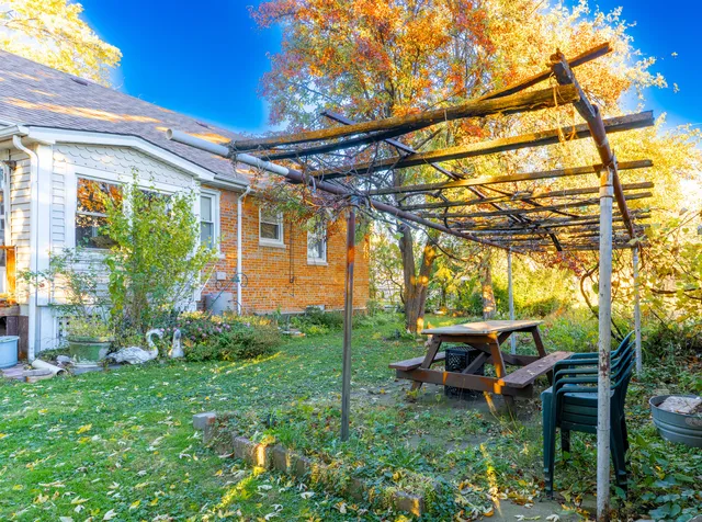 an aerial view of a house with a yard and trees all around