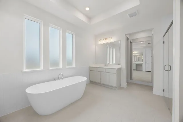 a bathroom with a white tub shower and sink