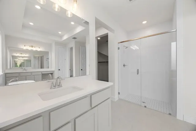 a bathroom with a sink shower and a mirror
