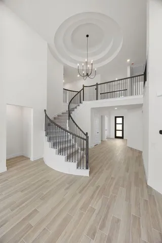 an empty room with wooden floor a ceiling fan and windows