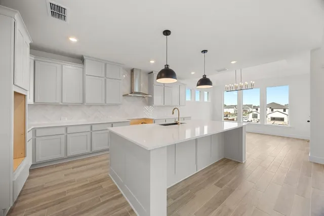 a view of a kitchen with kitchen island a sink stainless steel appliances and cabinets