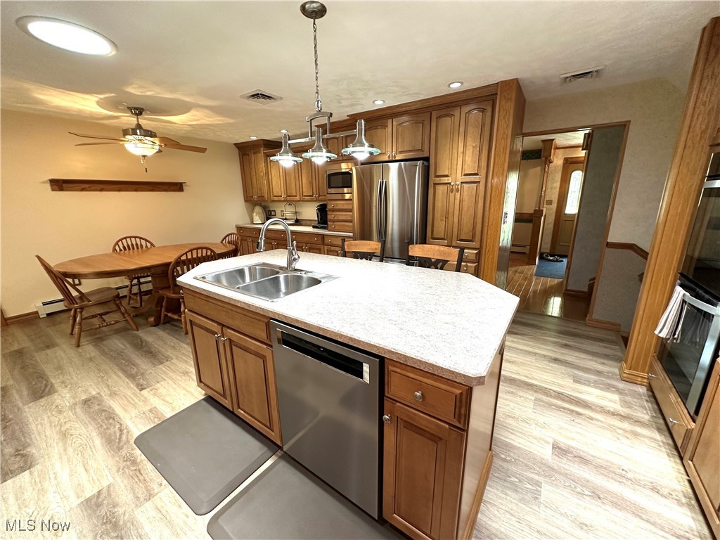 1684 Morris Street Mineral Ridge, OH 44440 - Photo 24 of 50 Kitchen with stainless steel appliances, brown cabinets, a sink, ceiling fan, and light wood-style flooring