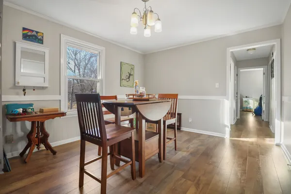 a view of a dining room with furniture wooden floor and a chandelier