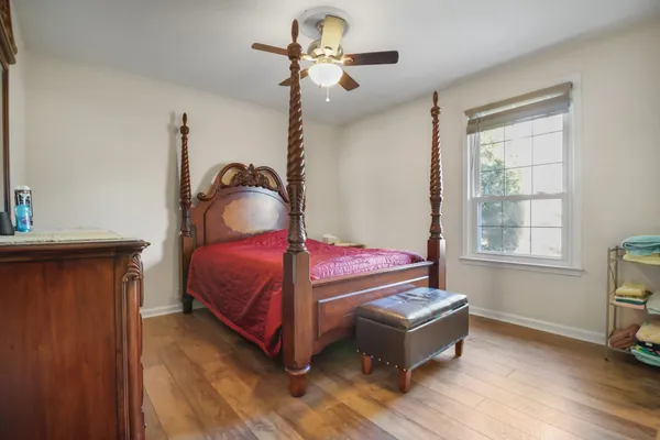 a bedroom with a bed dresser and a window