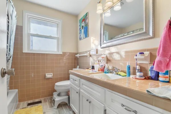 a bathroom with a sink a toilet and a mirror
