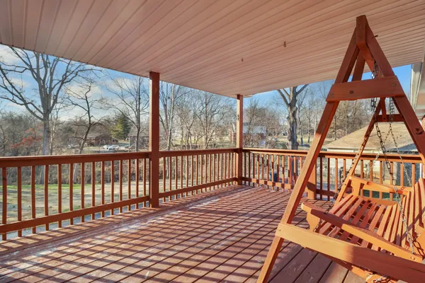 a balcony with wooden floor and outdoor seating