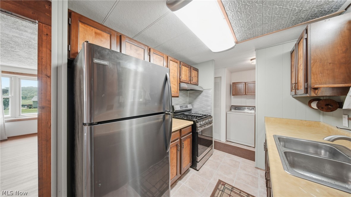 337 Wadesville Road Washington, WV 26181 - Photo 12 of 36 Kitchen featuring wood cabinetry, stainless steel refrigerator, stainless steel gas range, and a double basin sink
