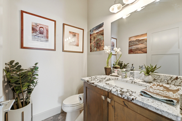 560 Aspen Road Francis, UT 84036 - Photo 33 of 59 Spa-inspired bathroom featuring a wood-finish vanity with dual sinks, granite-look countertop, and polished chrome fixtures
