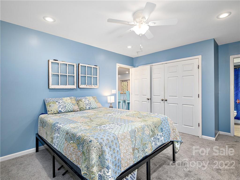 1908 Kims Cove Road Canton, NC 28716 - Photo 13 of 31 a bedroom with a large bed and a chandelier