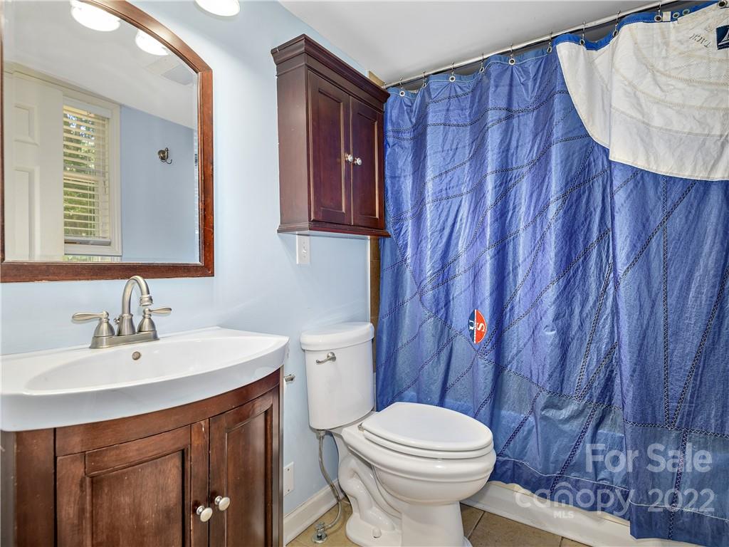 1908 Kims Cove Road Canton, NC 28716 - Photo 14 of 31 a bathroom with a sink a toilet and shower curtain