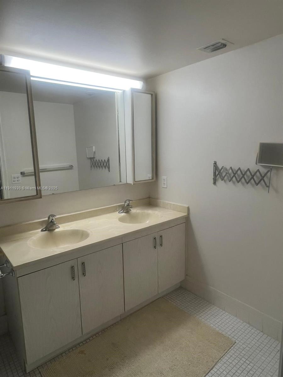 3102 Portofino Point, Unit M2 Coconut Creek, FL 33066 - Photo 19 of 26 a bathroom with a double vanity sink and mirror