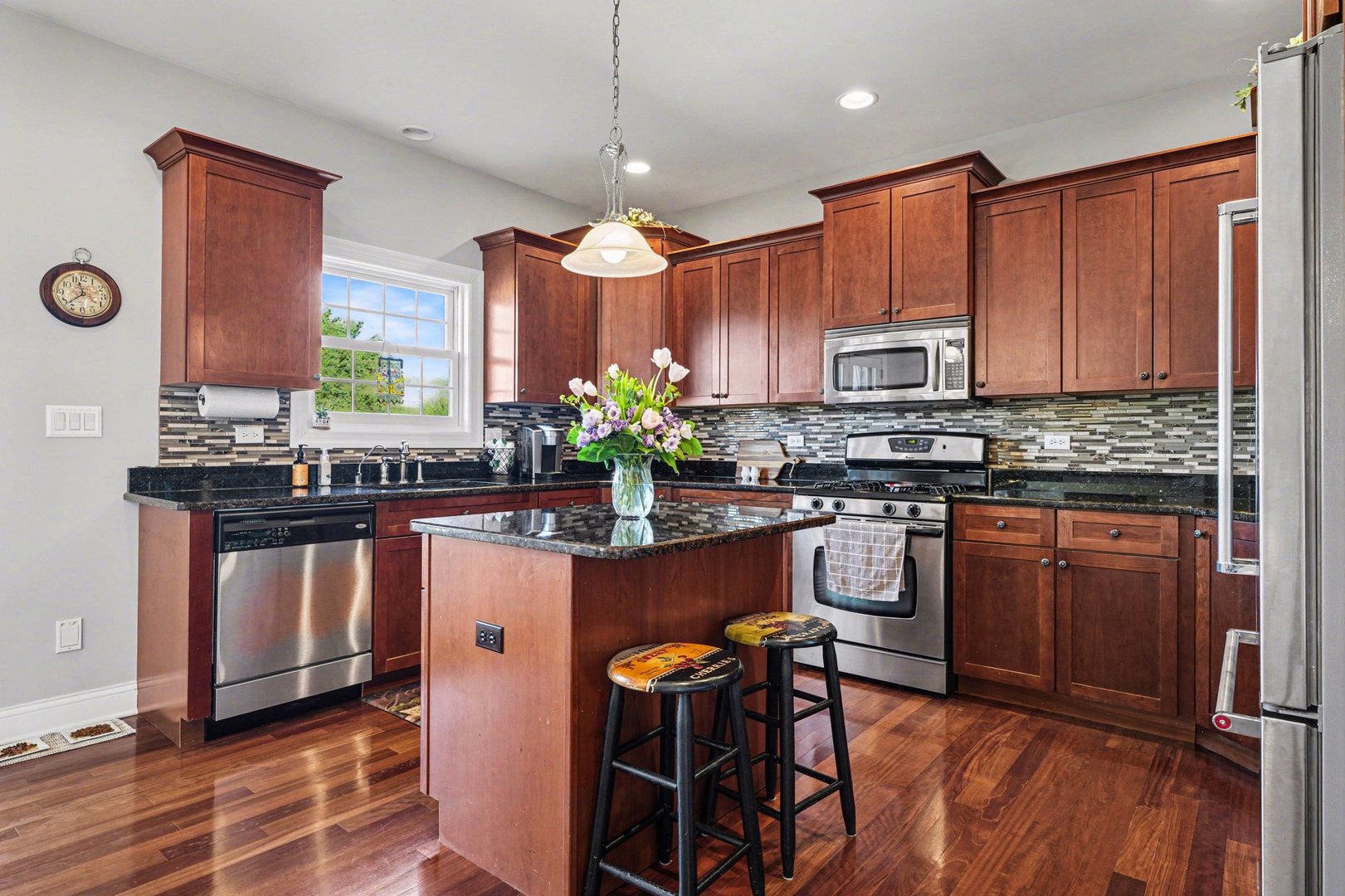 1744 East Offner Road Beecher, IL 60401 - Photo 16 of 49 a kitchen with stainless steel appliances granite countertop a stove a sink dishwasher and a refrigerator with wooden floor
